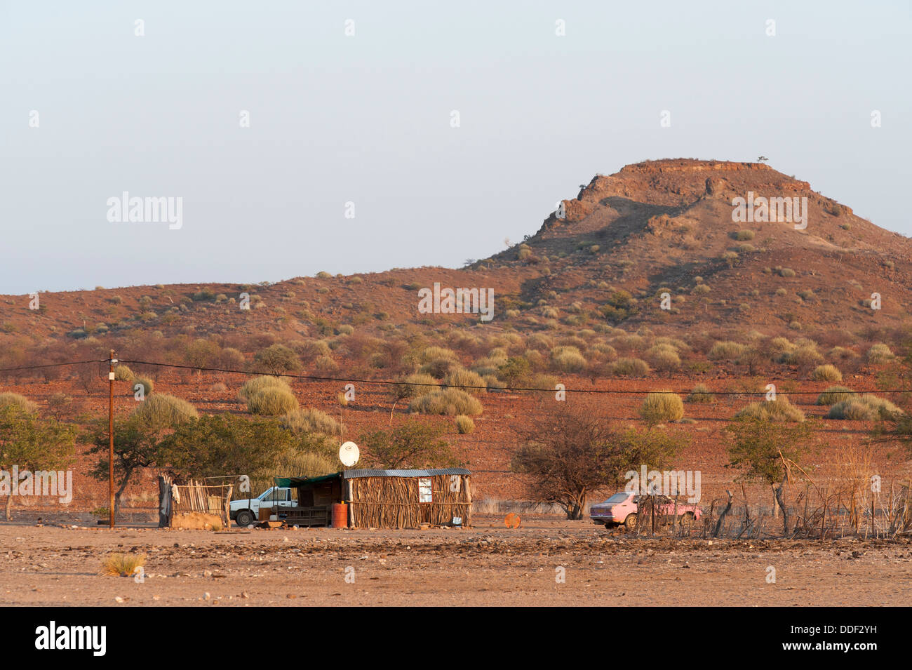 Two cars parked at a kiosk with satellite dish in a dry landscape, Kunene Region, Namibia Stock Photo