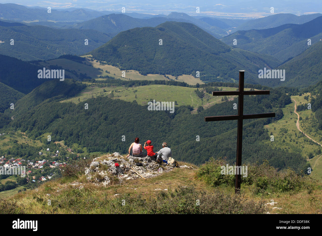 Three people looking on village Zliechov from Strazov peak, Strazovske vrchy, Slovakia. Stock Photo