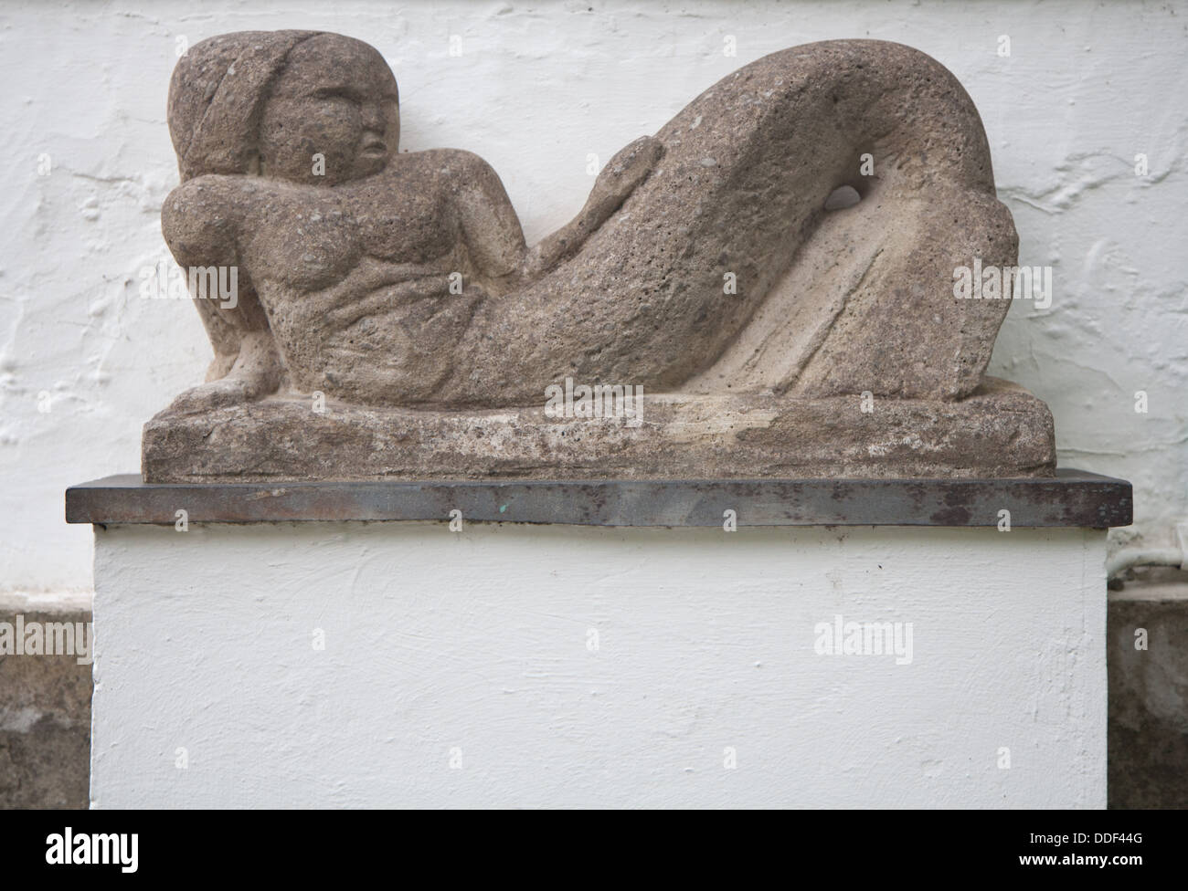 Stone carving / statue of a reclining woman / mermaid in Portmeirion Village Stock Photo