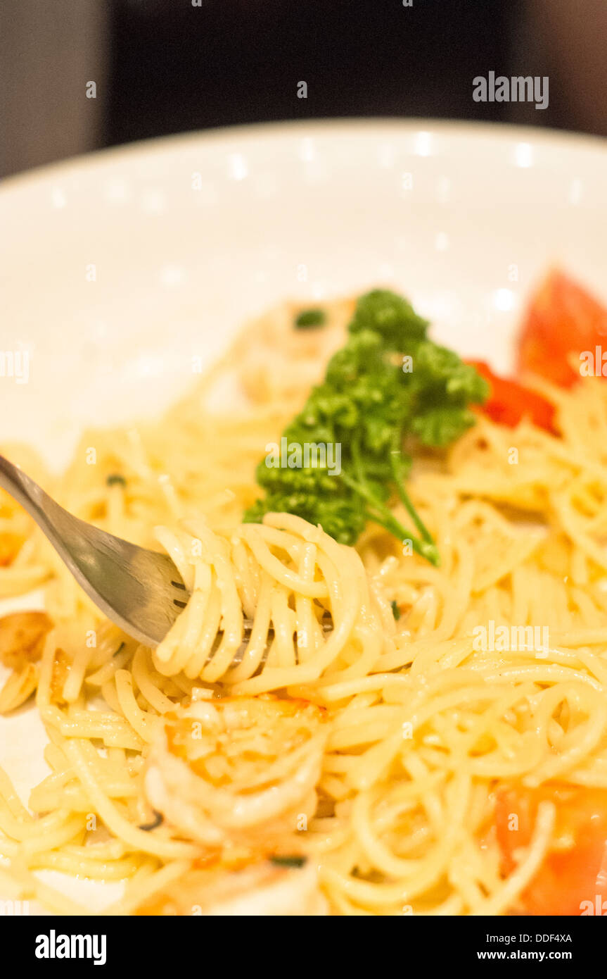 eating pasta spaghetti with fork, with spaghetti noodle on fork tips. Stock Photo