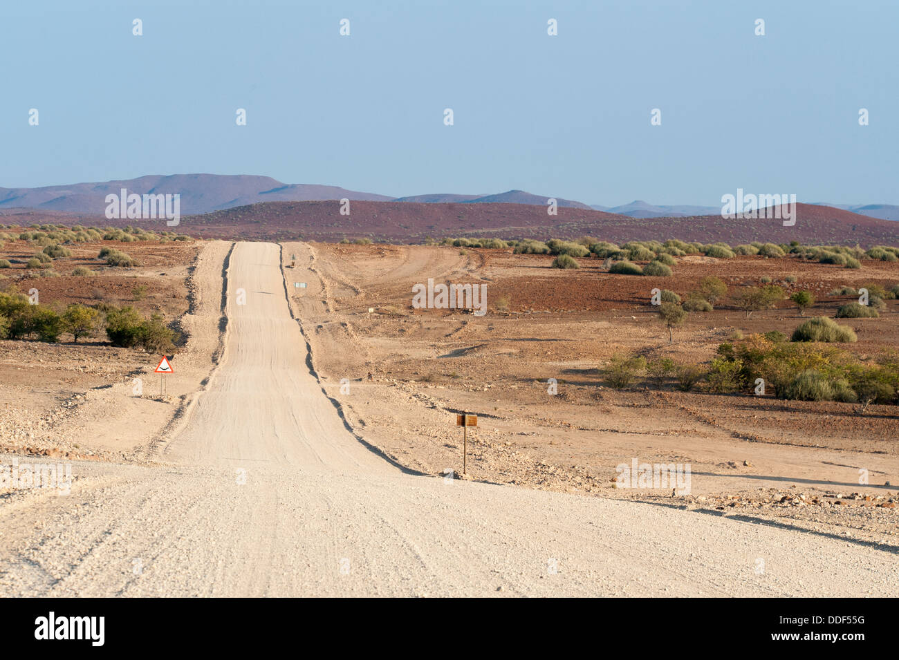 Wide, straight gravel road in dry landscape, Kunene Region, Namibia Stock Photo
