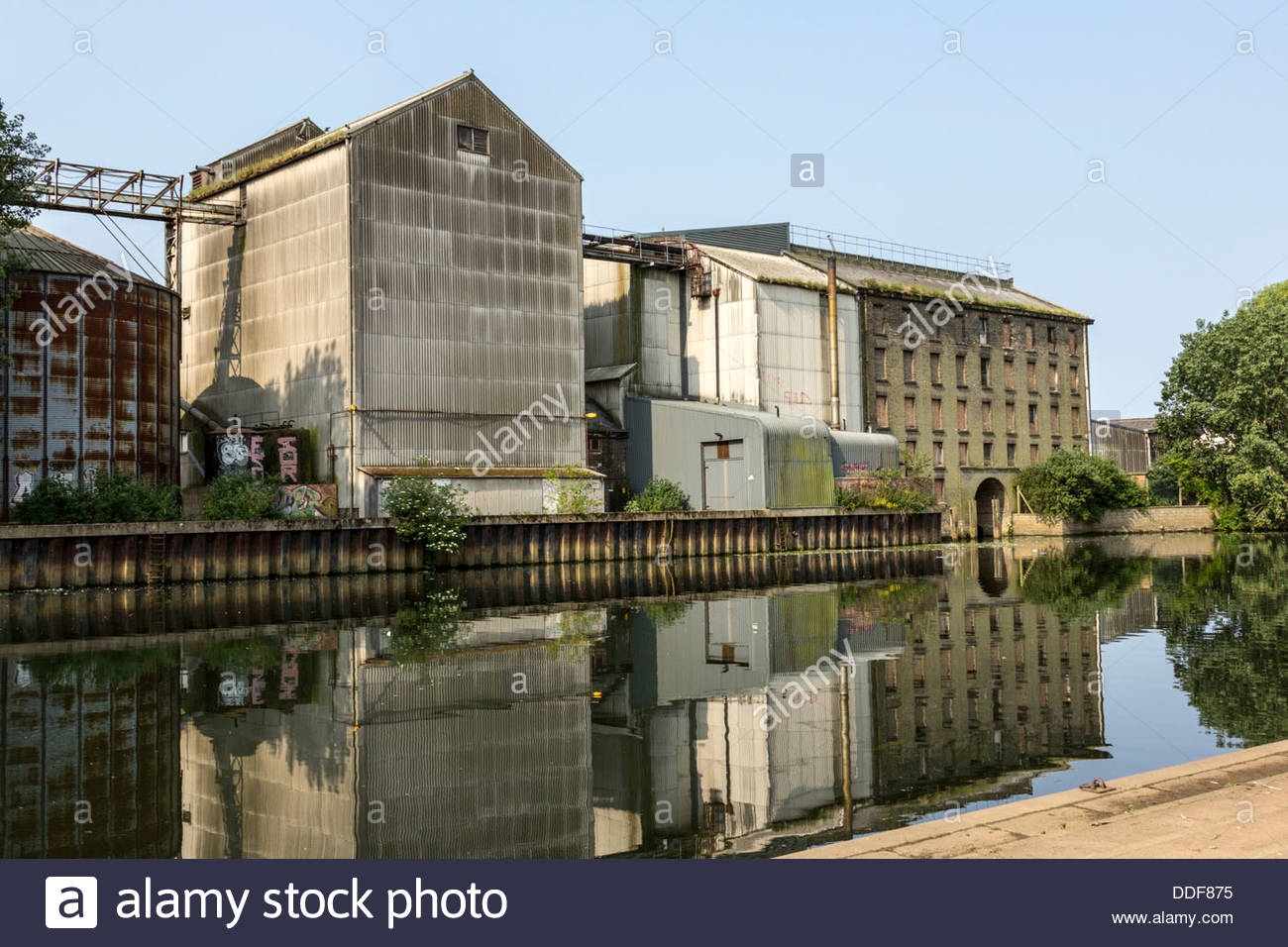 Disused industrial buildings along the River Nene embankment Stock