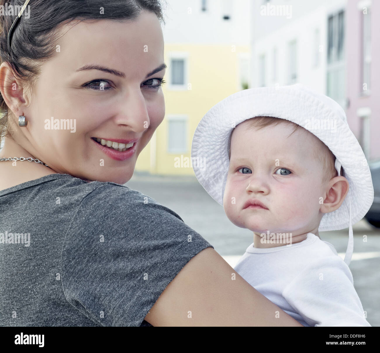 Caucasian baby girl with white hat and her mother. Stock Photo