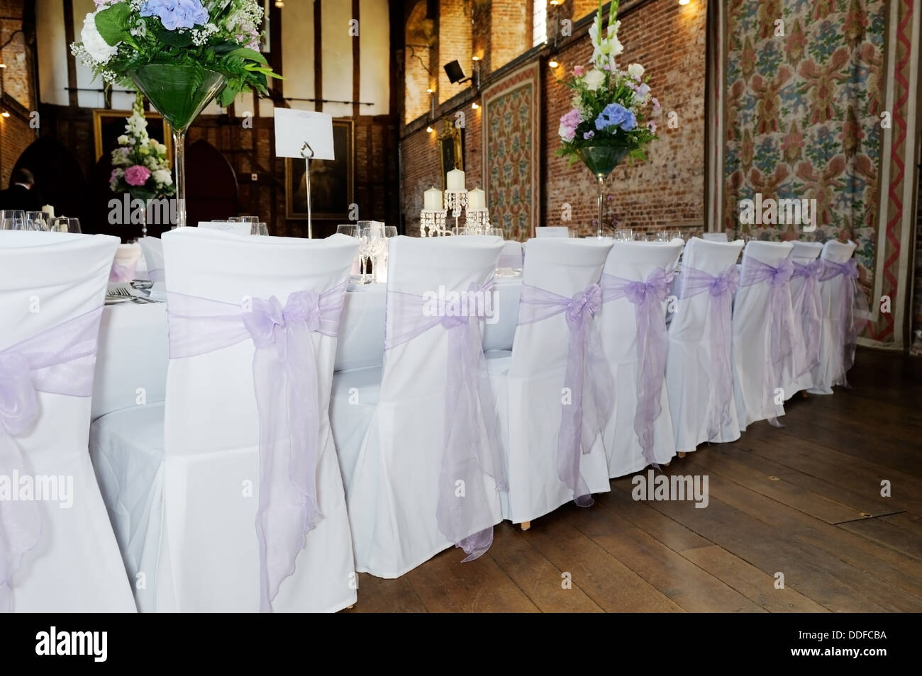 Back of chairs showing white and lilac covers at wedding reception Stock Photo