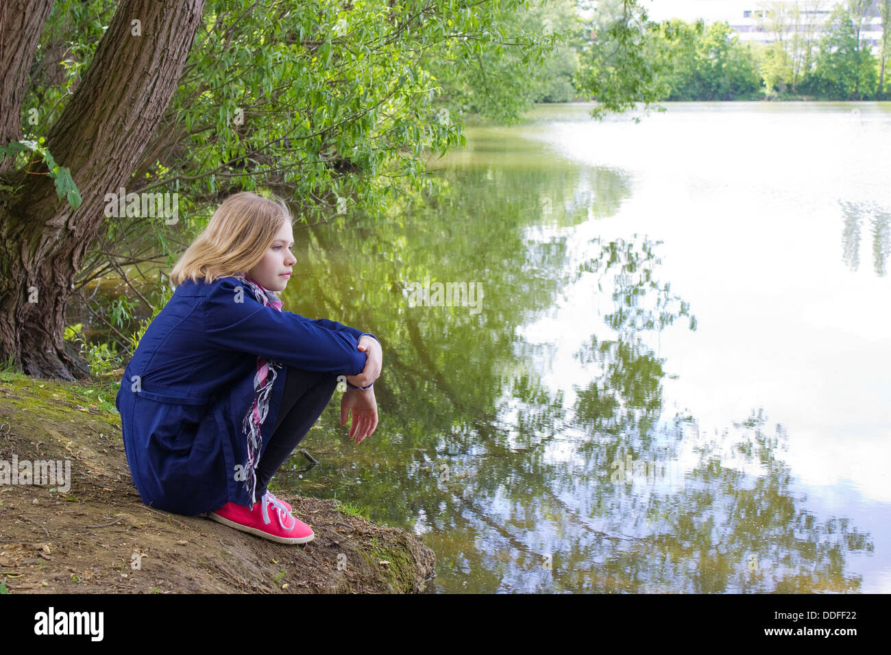 little girl sitting by the water Stock Photo - Alamy