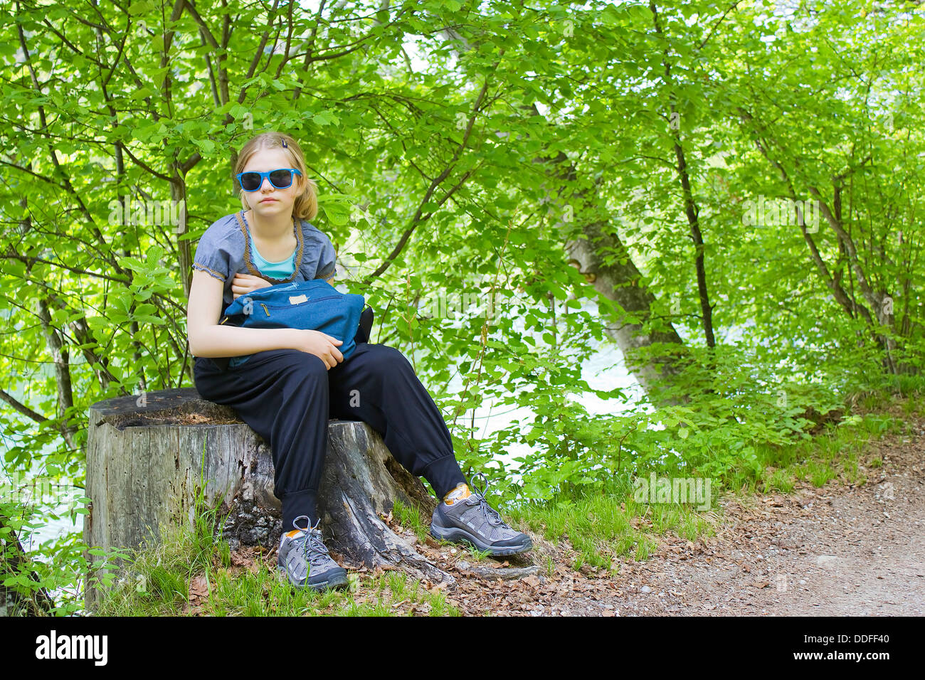 little girl sitting on a stump in the forest Stock Photo - Alamy