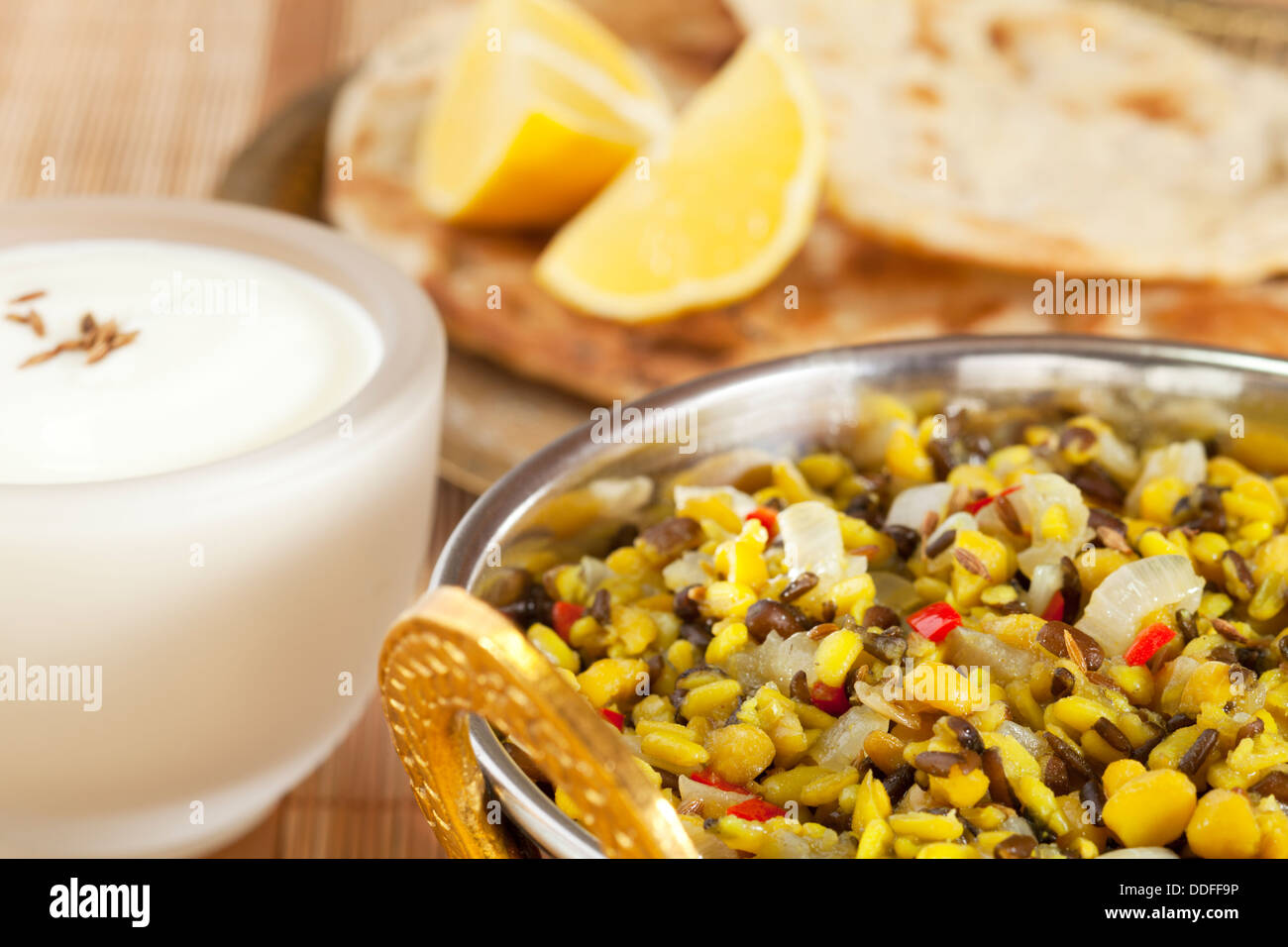 Dhal Indian Vegetarian Food - a bowl of Indian dhal or dal made from channa dhal and urid dhal, with naan bread and yoghurt. Stock Photo