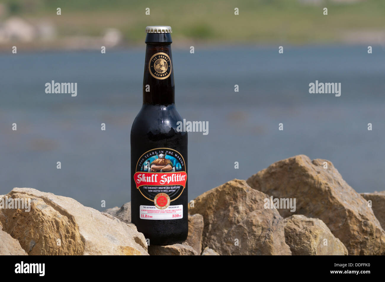 A bottle of the Orkney Brewery's Skull Splitter Rich Ale, in front of the Bay of First, Mainland, Orkney. Stock Photo