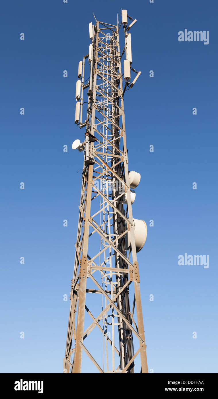 Communication radio tower with devices above blue sky Stock Photo