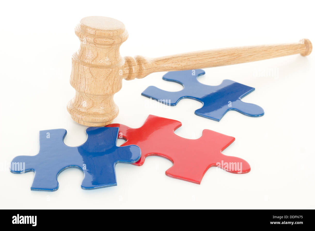 Wooden gavel hitting colourful puzzle pieces Stock Photo Alamy