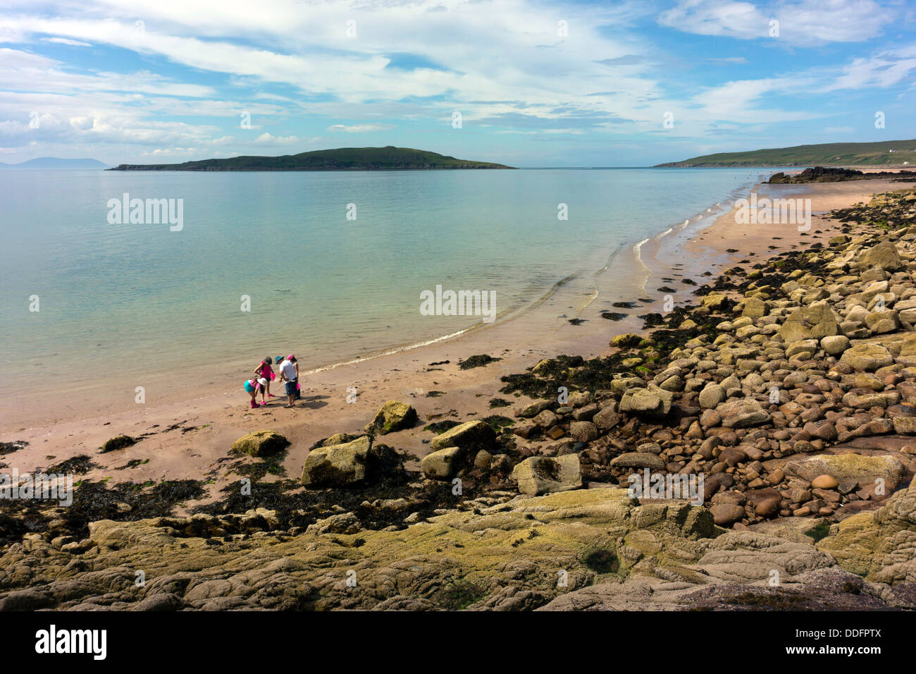 Family group on deserted sandy beach, blue sea and sky, Gairloch, Northwest Scotland Stock Photo