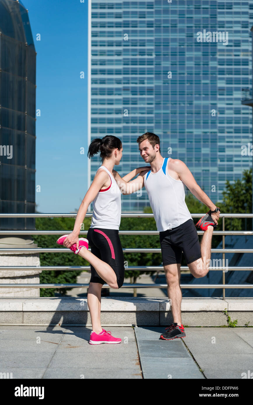 Sport couple exercising and stretching muscles before jogging activity in city Stock Photo