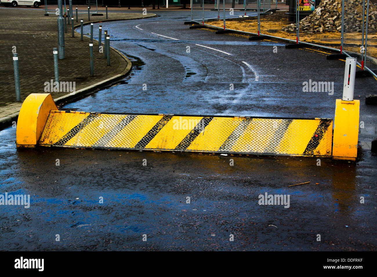 Raised security barrier across access road Stock Photo