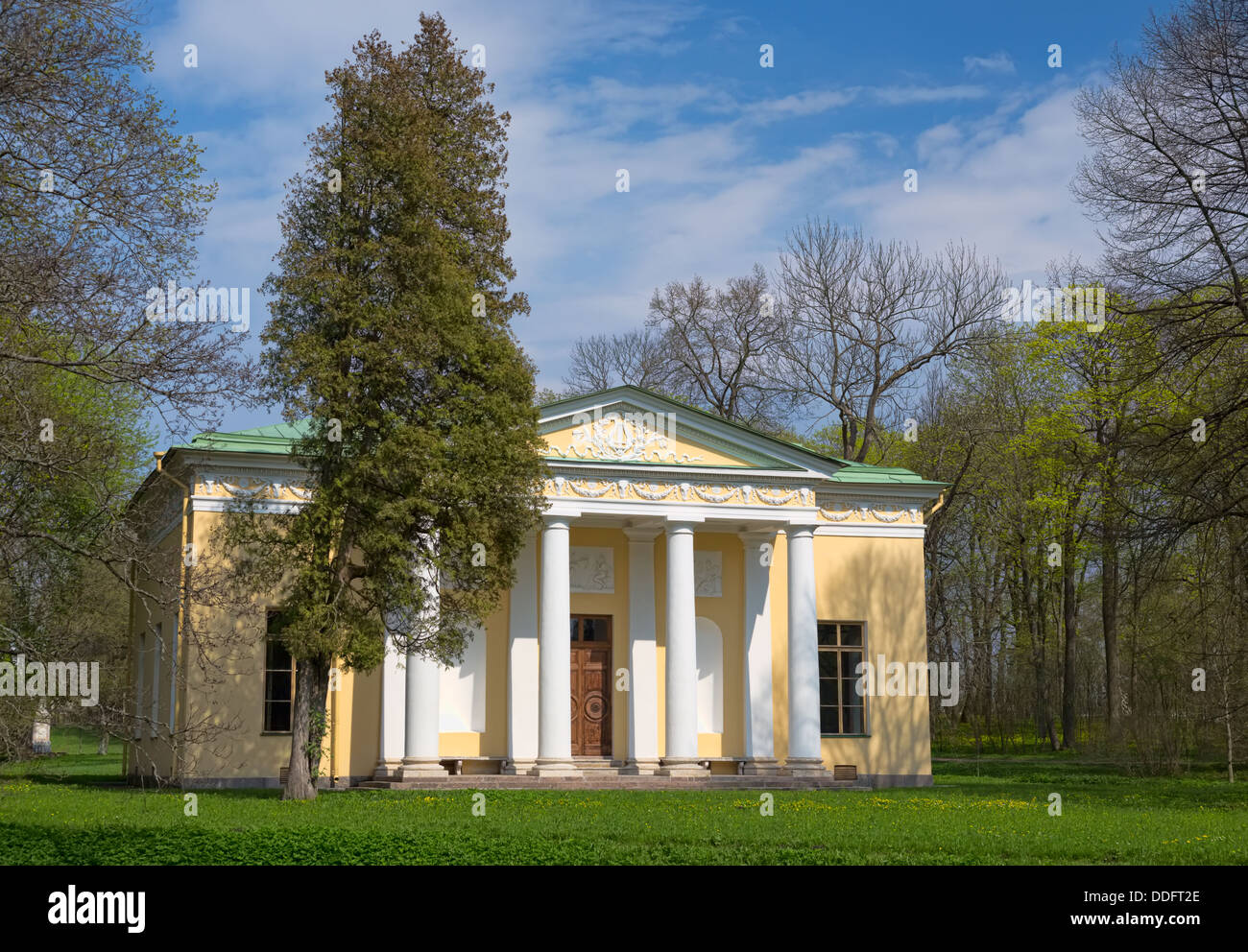 Old house with columns in the woods on a background of blue sky with ...