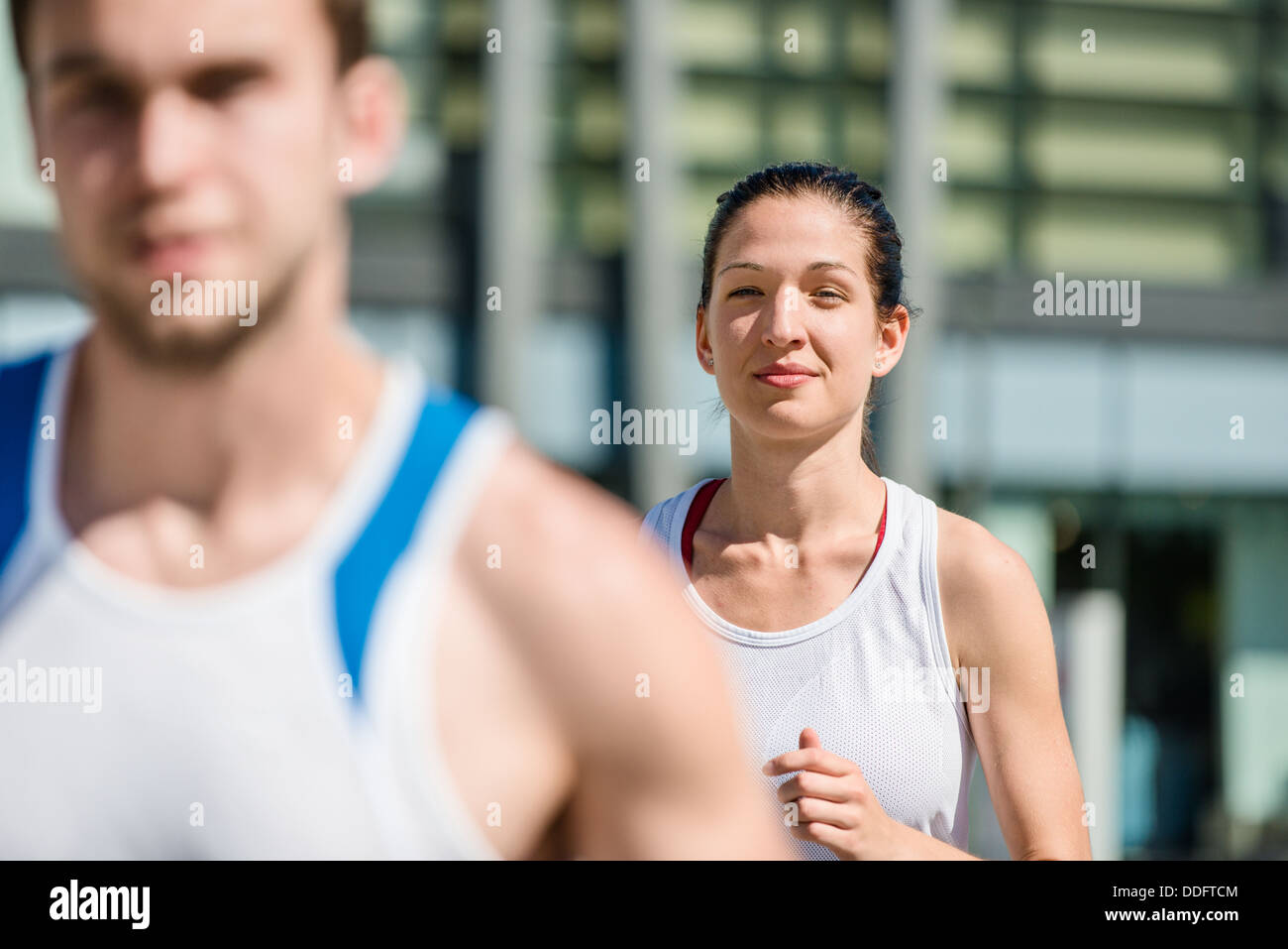 Young sport couple jogging in city environment - man cropped Stock Photo