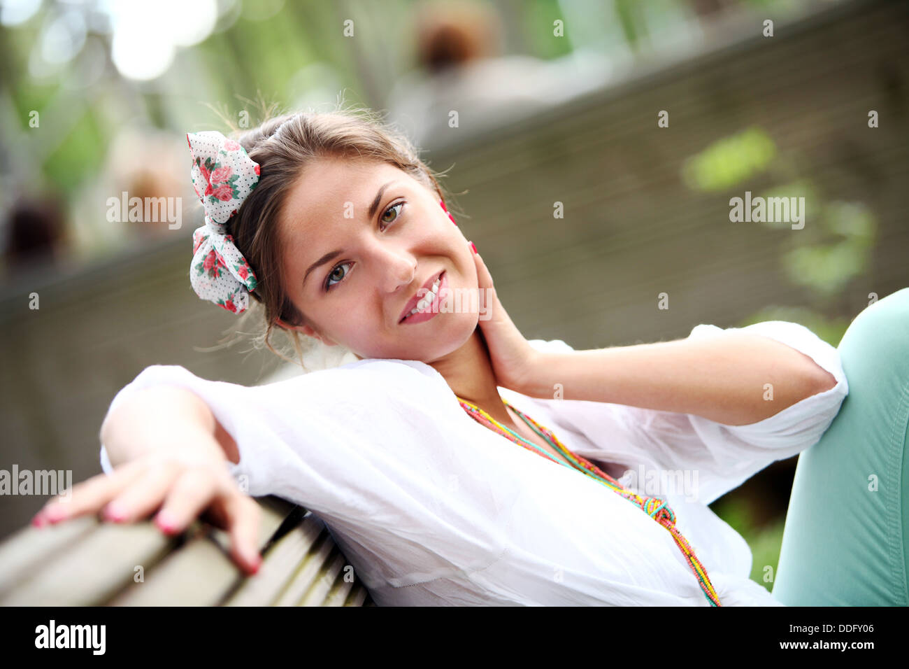 A beautiful woman is sitting on a park bench Stock Photo - Alamy