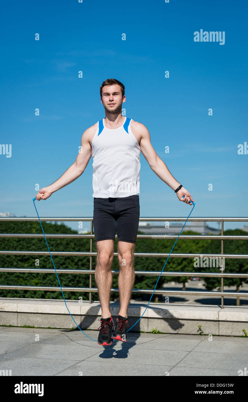 Young sport man exercising - jumping with skipping rope Stock Photo