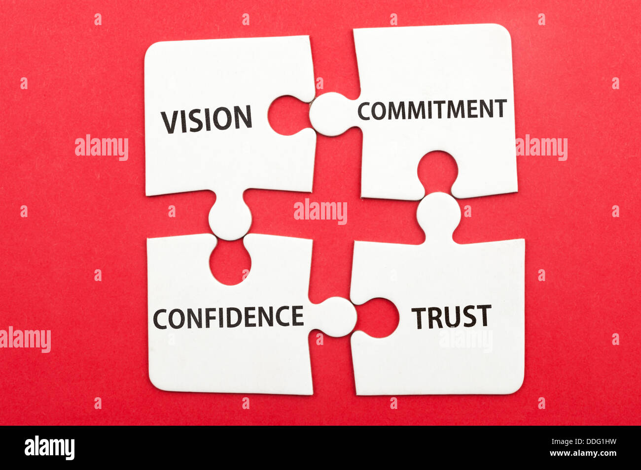 Business teamwork concept of vision, commitment, confidence, trust written on group of jigsaw puzzle pieces Stock Photo