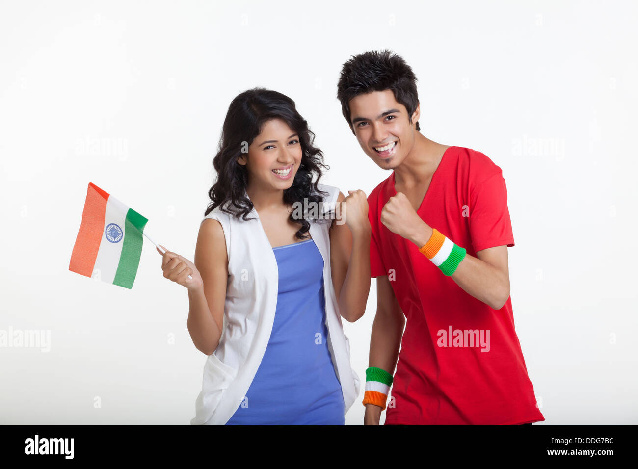 Portrait of young girl holding Indian flag while cheering with friend