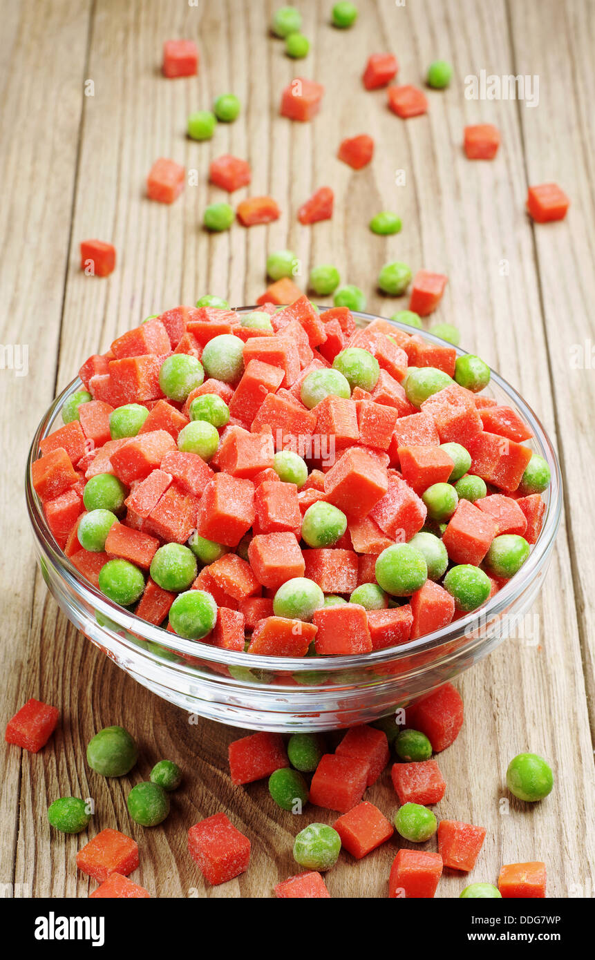 Frozen peas and carrots on a wooden table Stock Photo Alamy