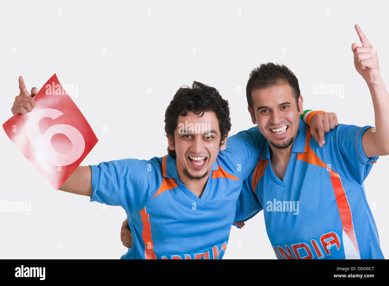 Portrait of happy young male friends Indian cricket team jerseys standing  together arm around over white background Stock Photo - Alamy