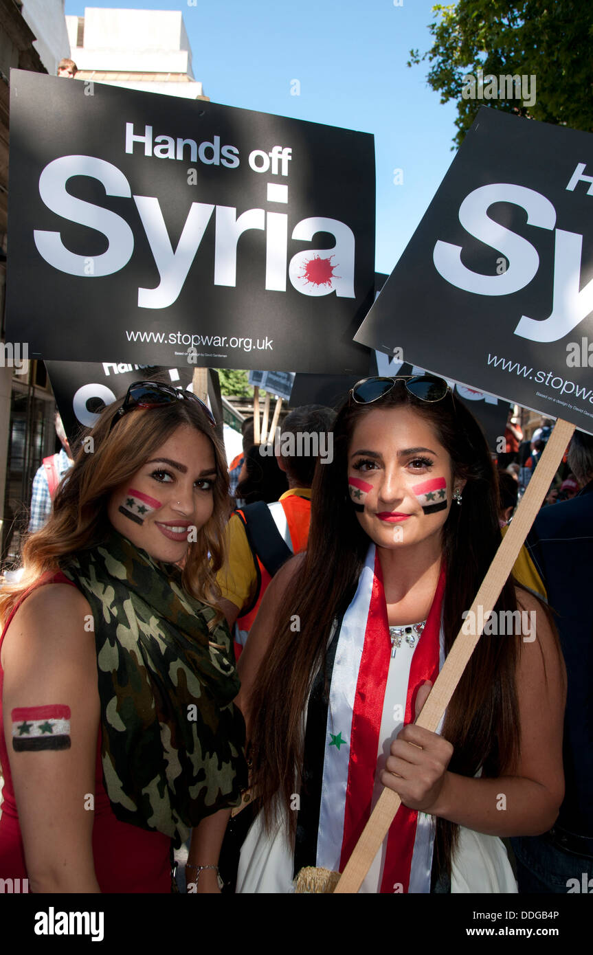 Demonstration against any intervention in Syria.Two young women have Syrian flags painted on their faces and hold placards Stock Photo