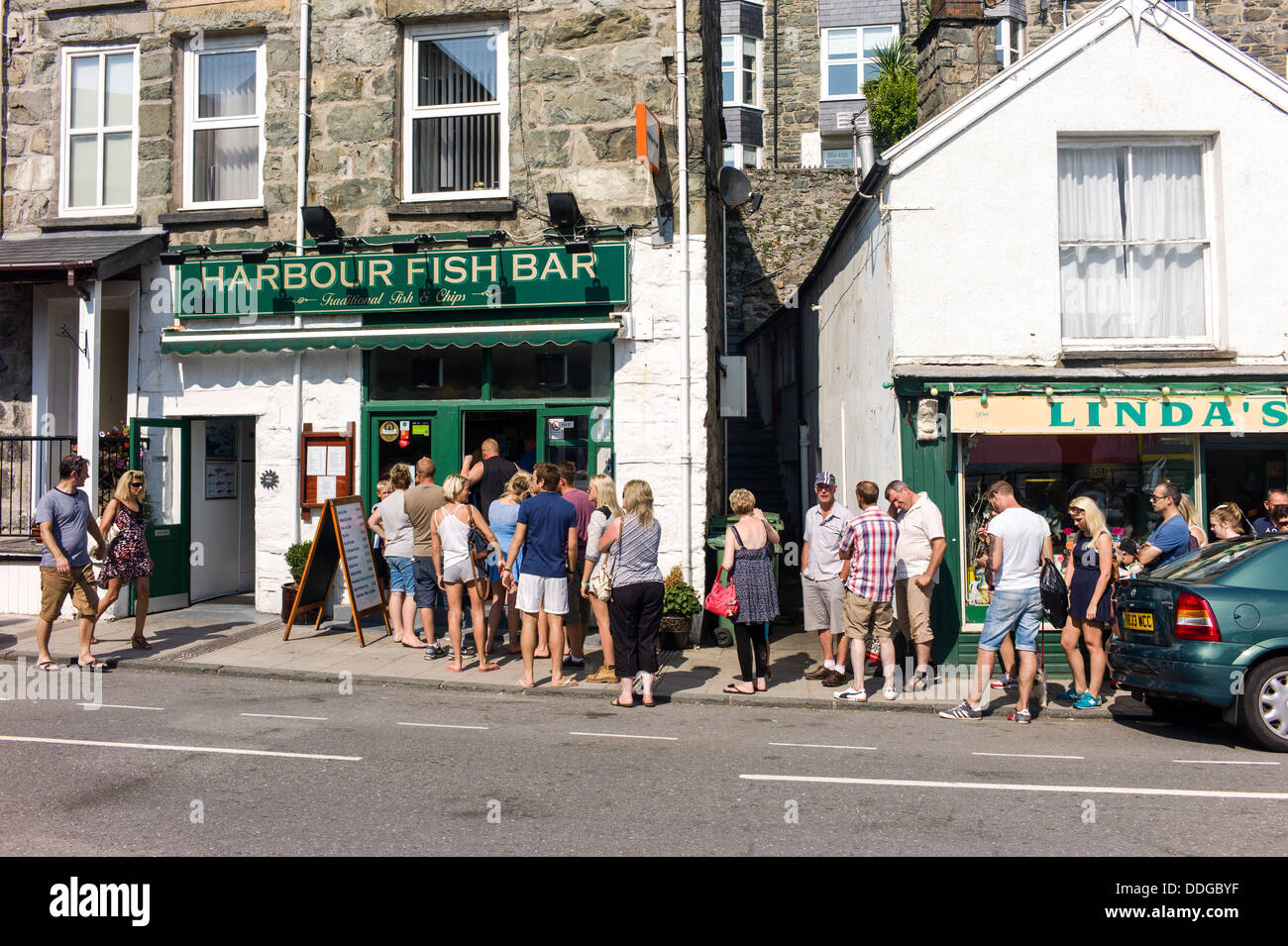 It's summertime and British holiday makers are forming an orderly queue for take away fish and chips at a coastal town Stock Photo
