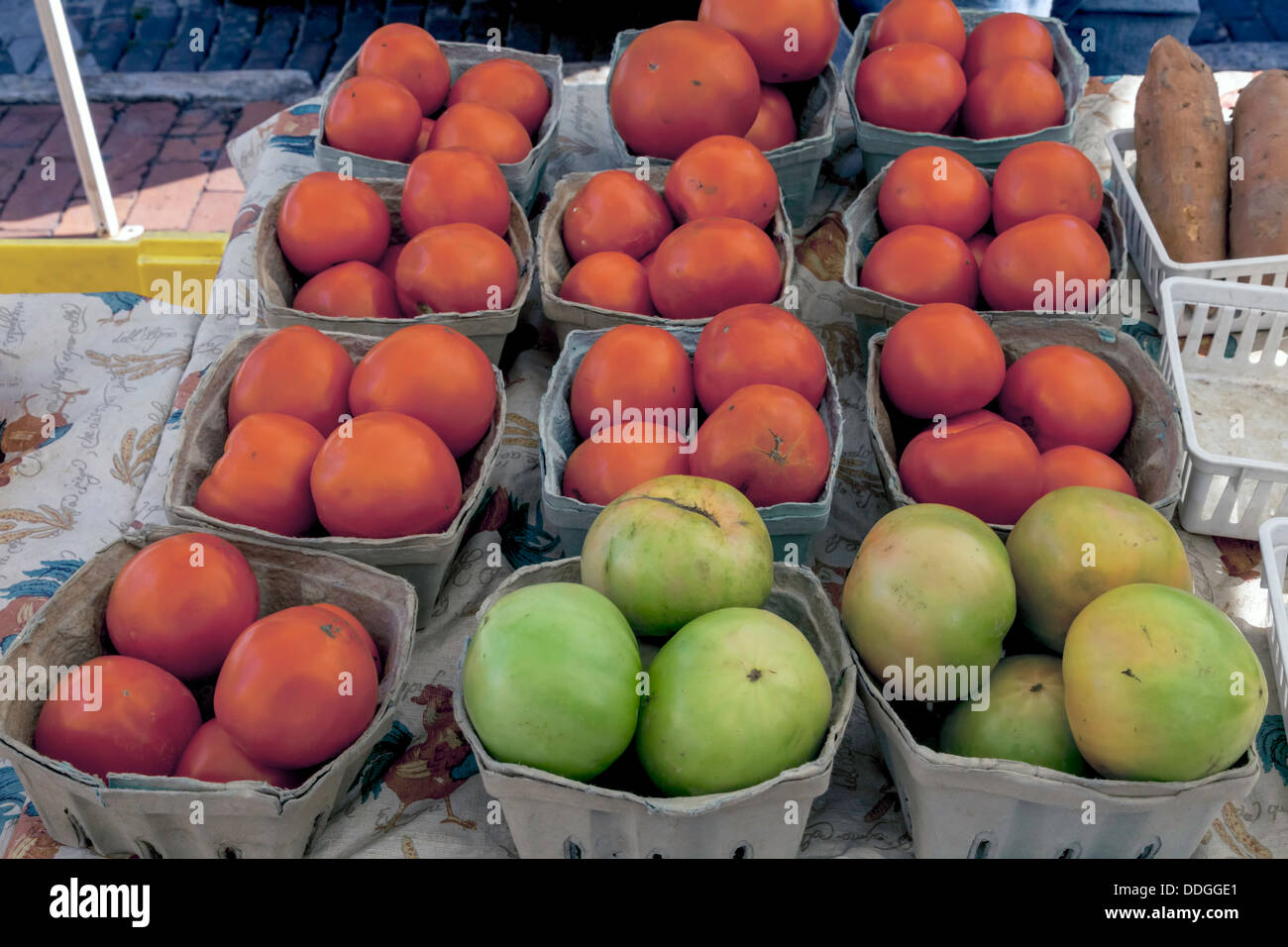 Baskets of organic red and green tomatoes for sale at a farmer's market ...