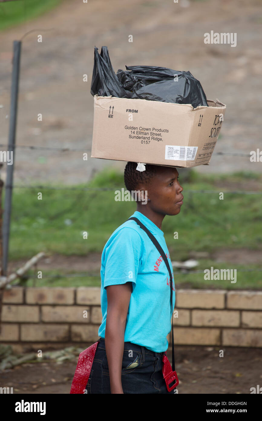 A woman carrying a box on her head Stock Photo Alamy