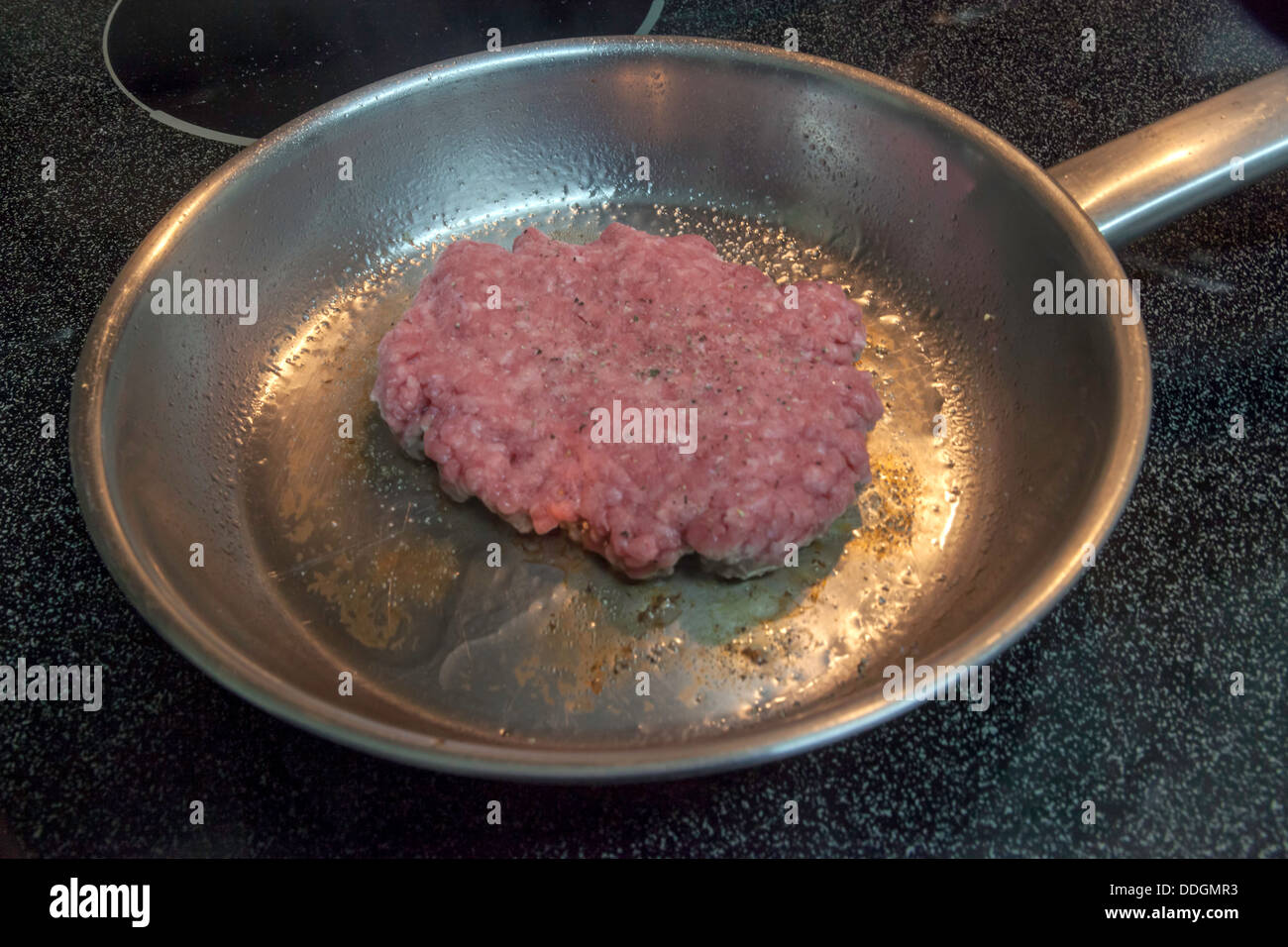 Greasy ground chuck hamburger patty frying in a small stainless steel frying pan Stock Photo Alamy