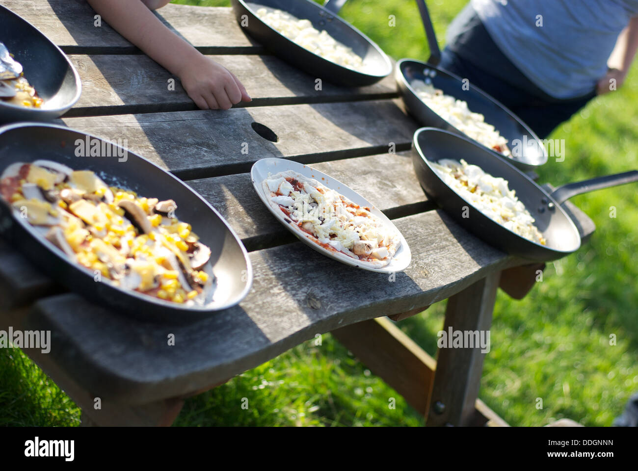 Fresh pizzas waiting to be put into the outdoor oven on a camping holiday Stock Photo