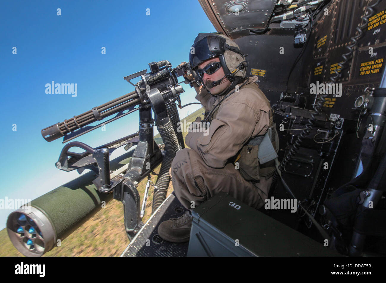 A US Marine door gunner searches for targets aboard a UH-1Y Venom helicopter during live-fire training as part of Exercise Koolendong September 2, 2013 in the Northern Territory, Australia. Stock Photo