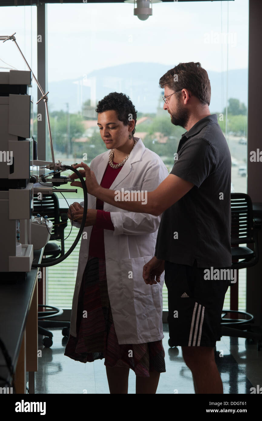 Researchers with mass spectrometer in lab Stock Photo