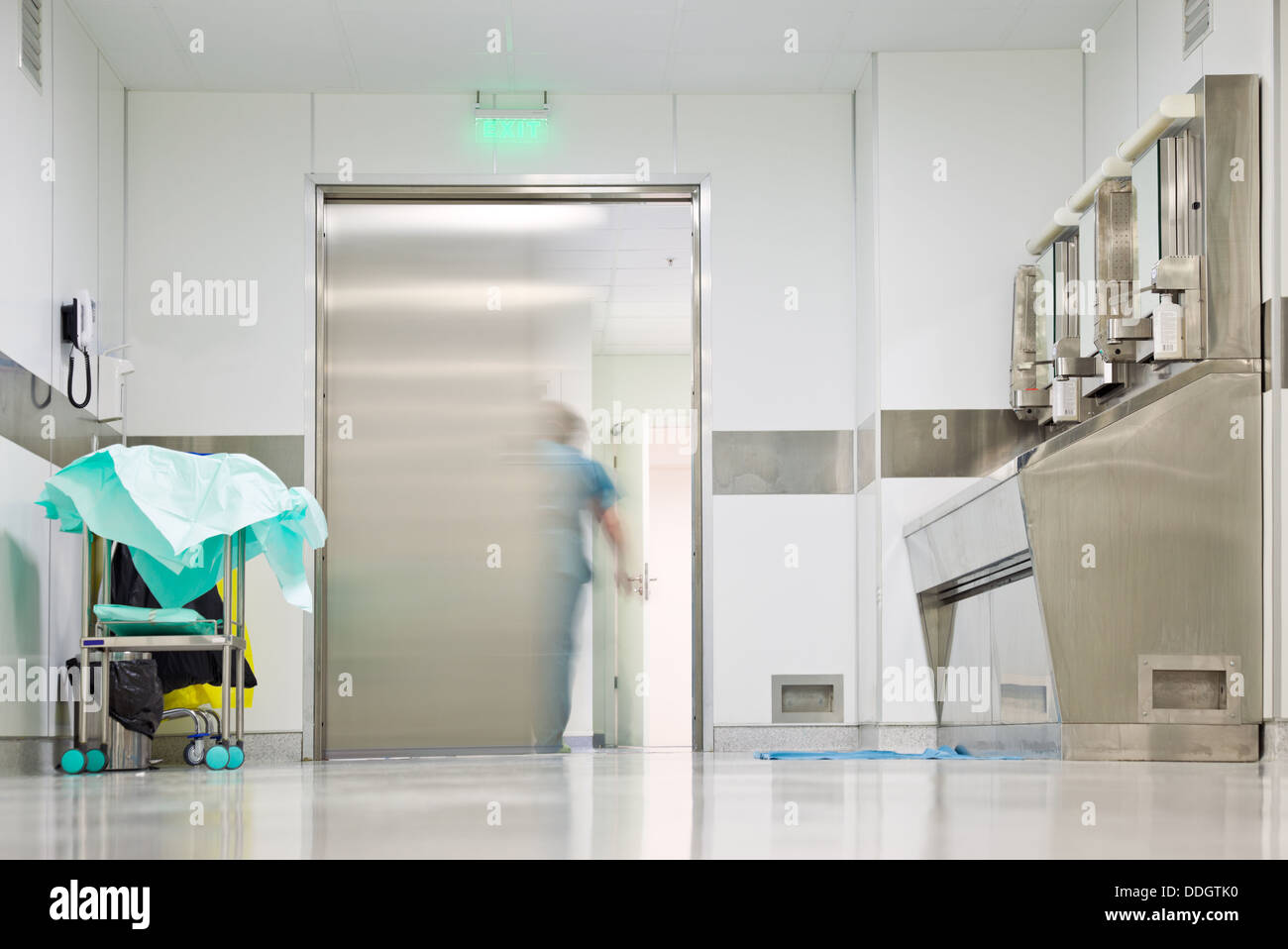 Blurred figure exiting hospital door Stock Photo