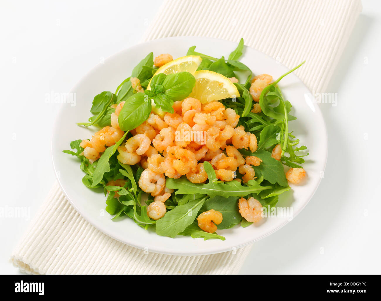 Spicy shrimps on bed of salad greens Stock Photo