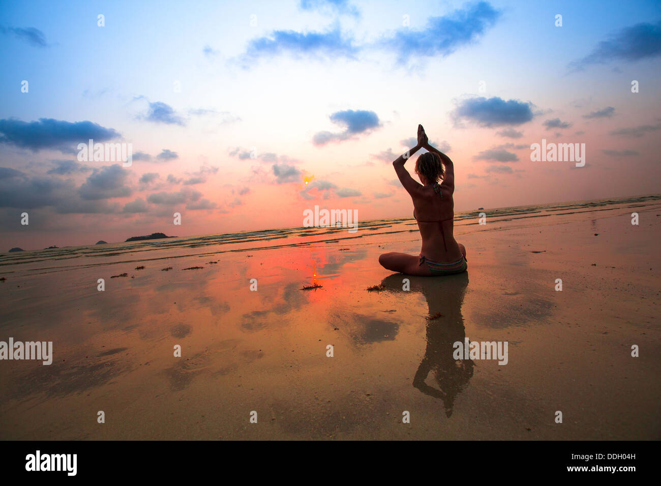 Silhouette of a woman yoga on sea sunset Stock Photo - Alamy