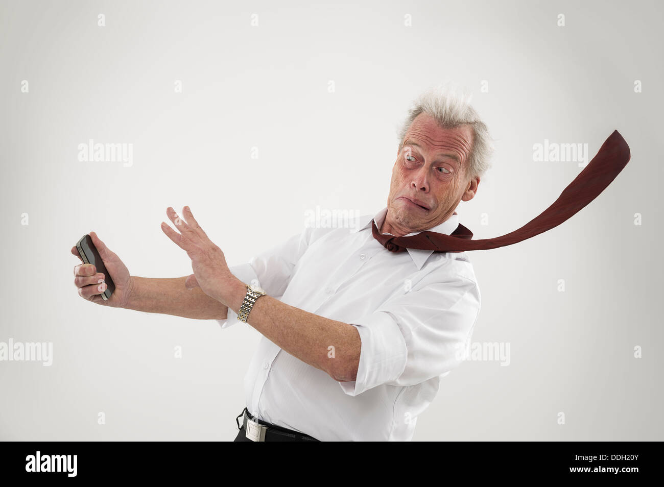 Senior businessman struck by high winds Stock Photo