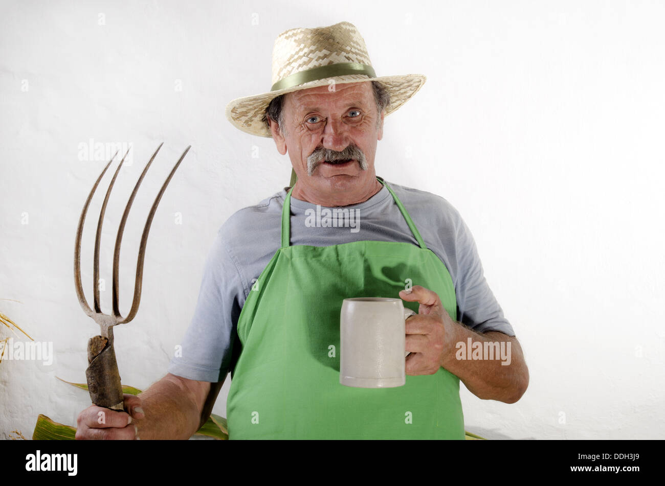 organic farmer with a pitchfork and a beer mug Stock Photo