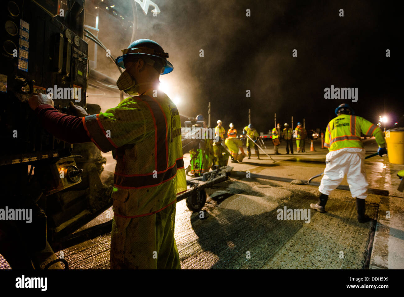 Construction workers from American Civil Constructors lay the final top ...