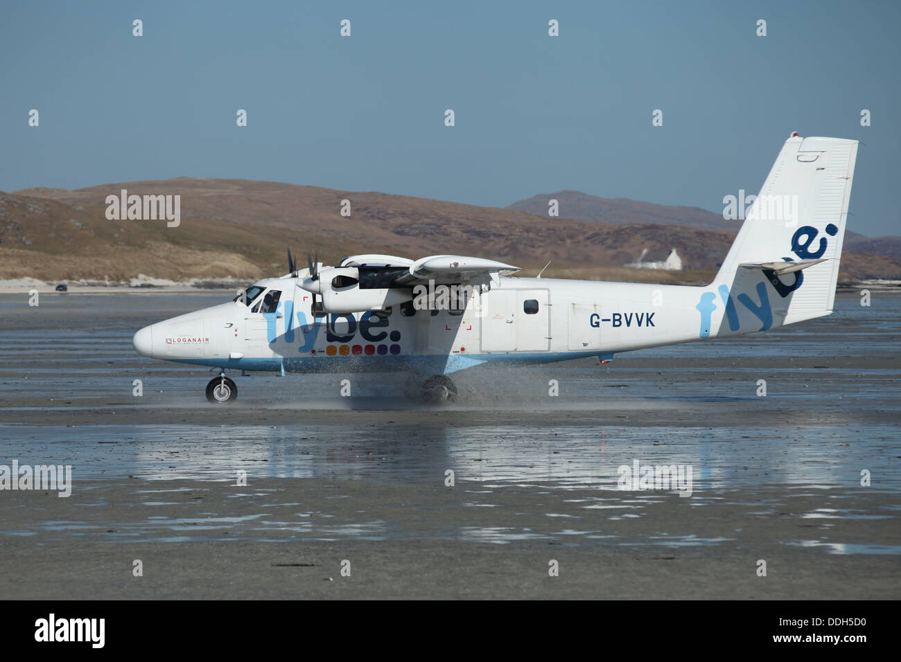 Flybe Twin Otter airplane landing on the Traigh Mhòr beach runway of  Barra Eoligarry Airport, Isle of Barra, Stock Photo
