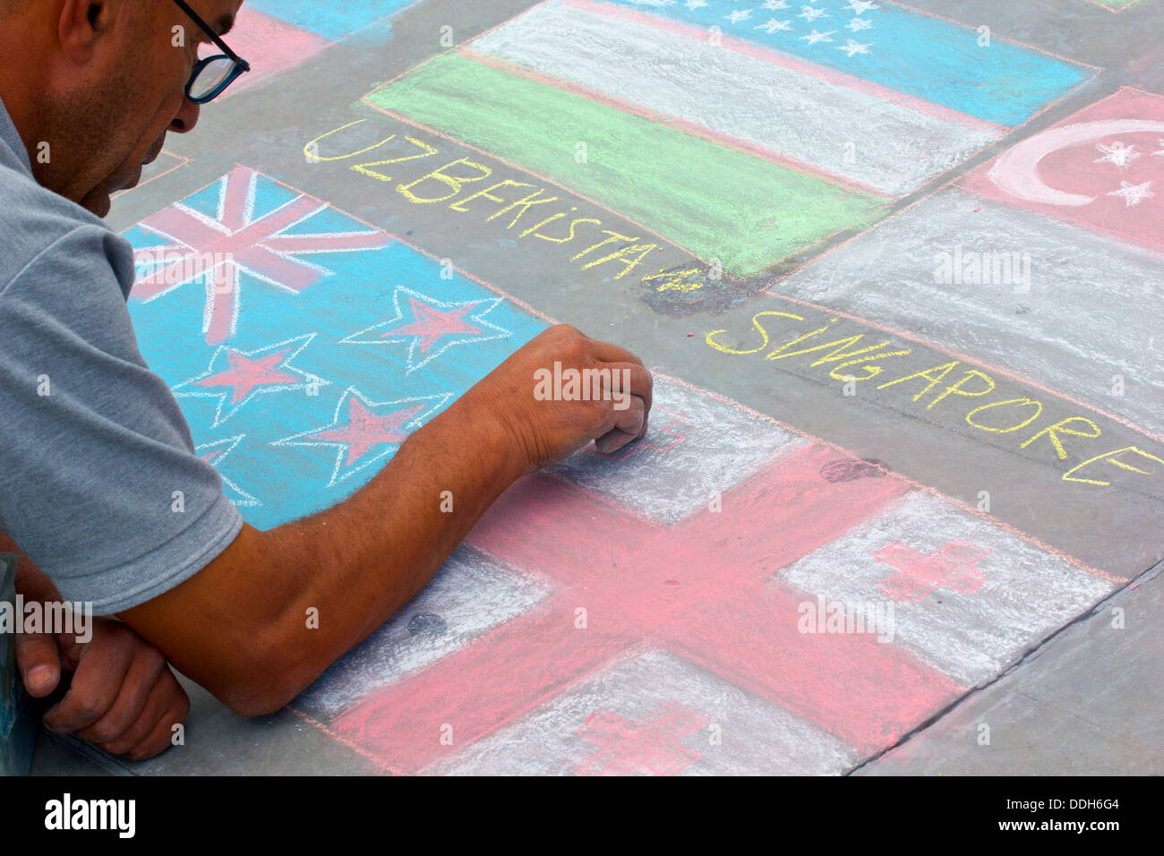 Street pavement artist drawing national flags with chalk Trafalgar Square London England Europe Stock Photo