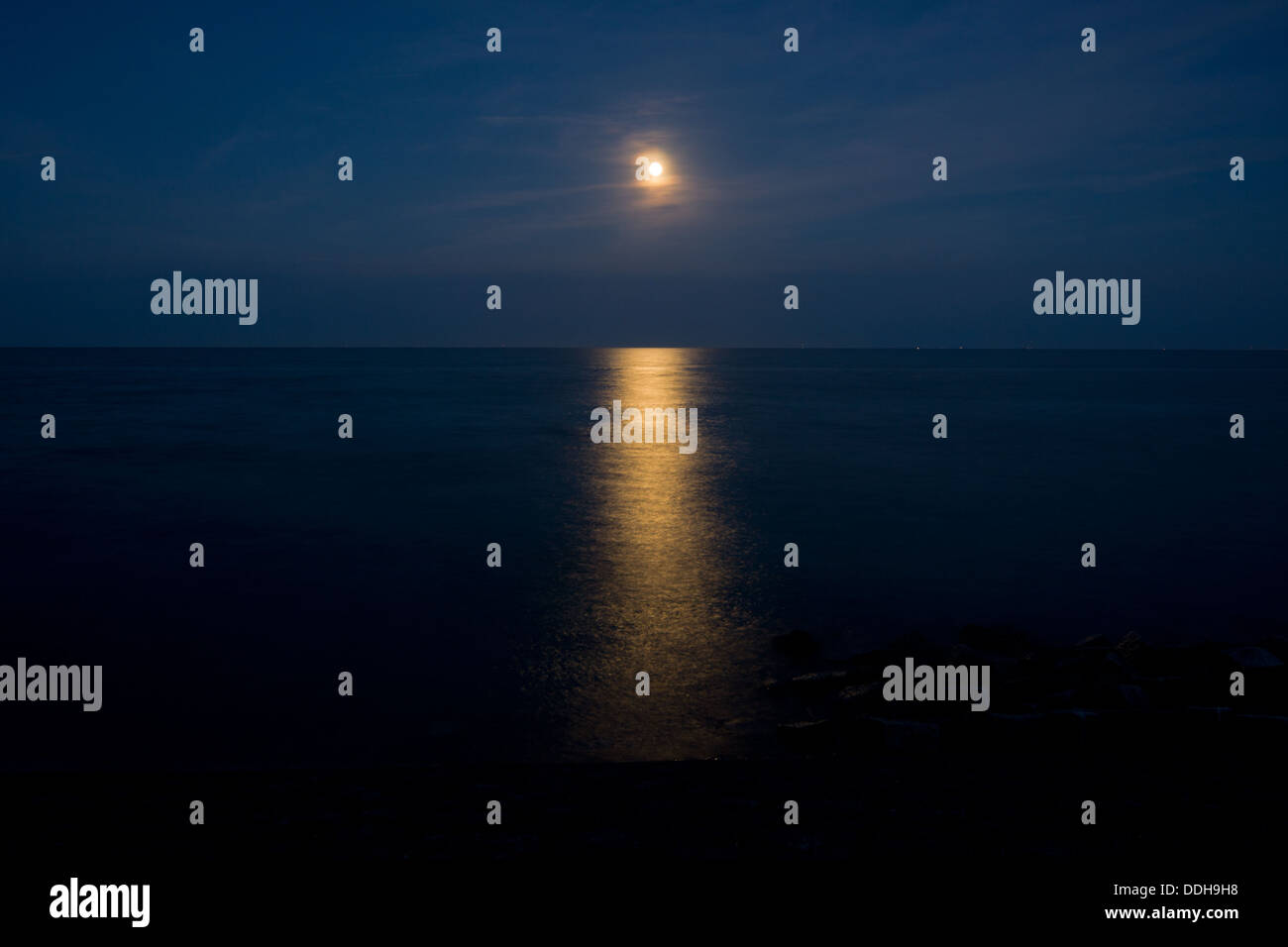 Full moon reflected in a dark sea Stock Photo
