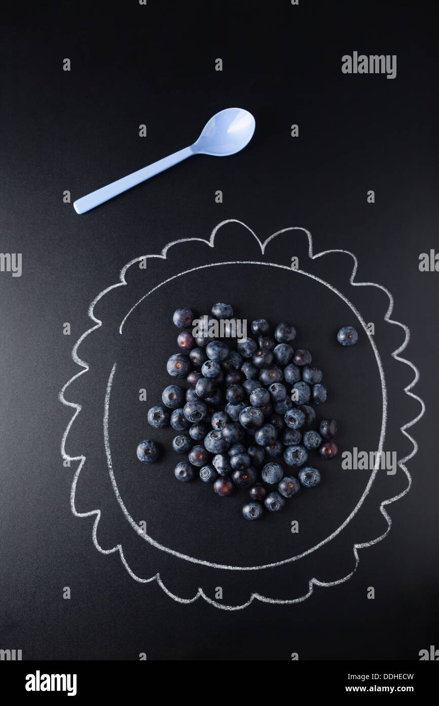 Blueberries on plate painted with chalk, close up Stock Photo