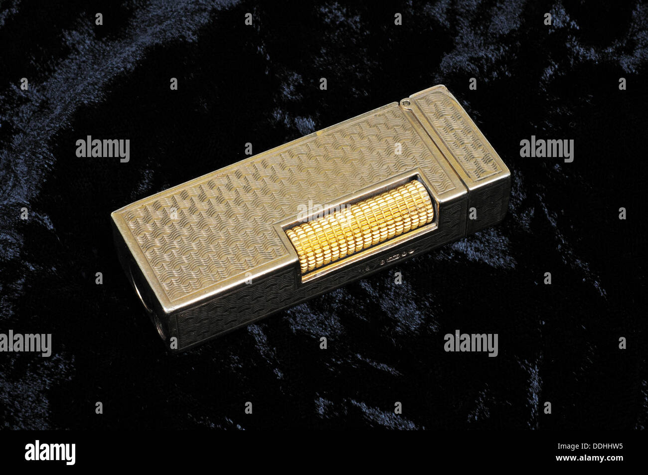 Dunhill gold cigarette lighter against a dark background. Stock Photo