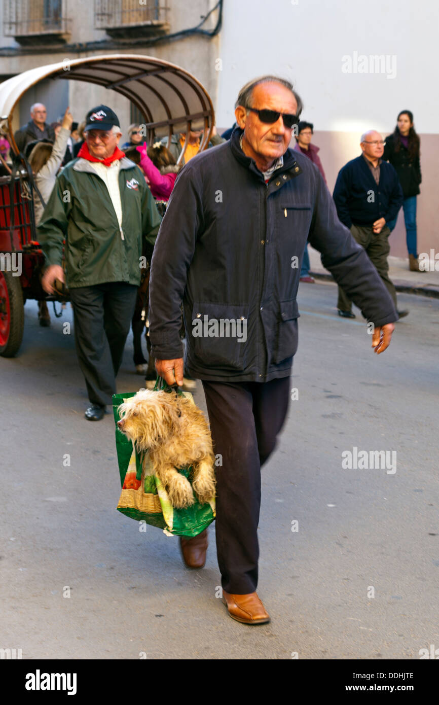 Man carrying dog in carrier bag at Spanish festival Stock Photo Alamy