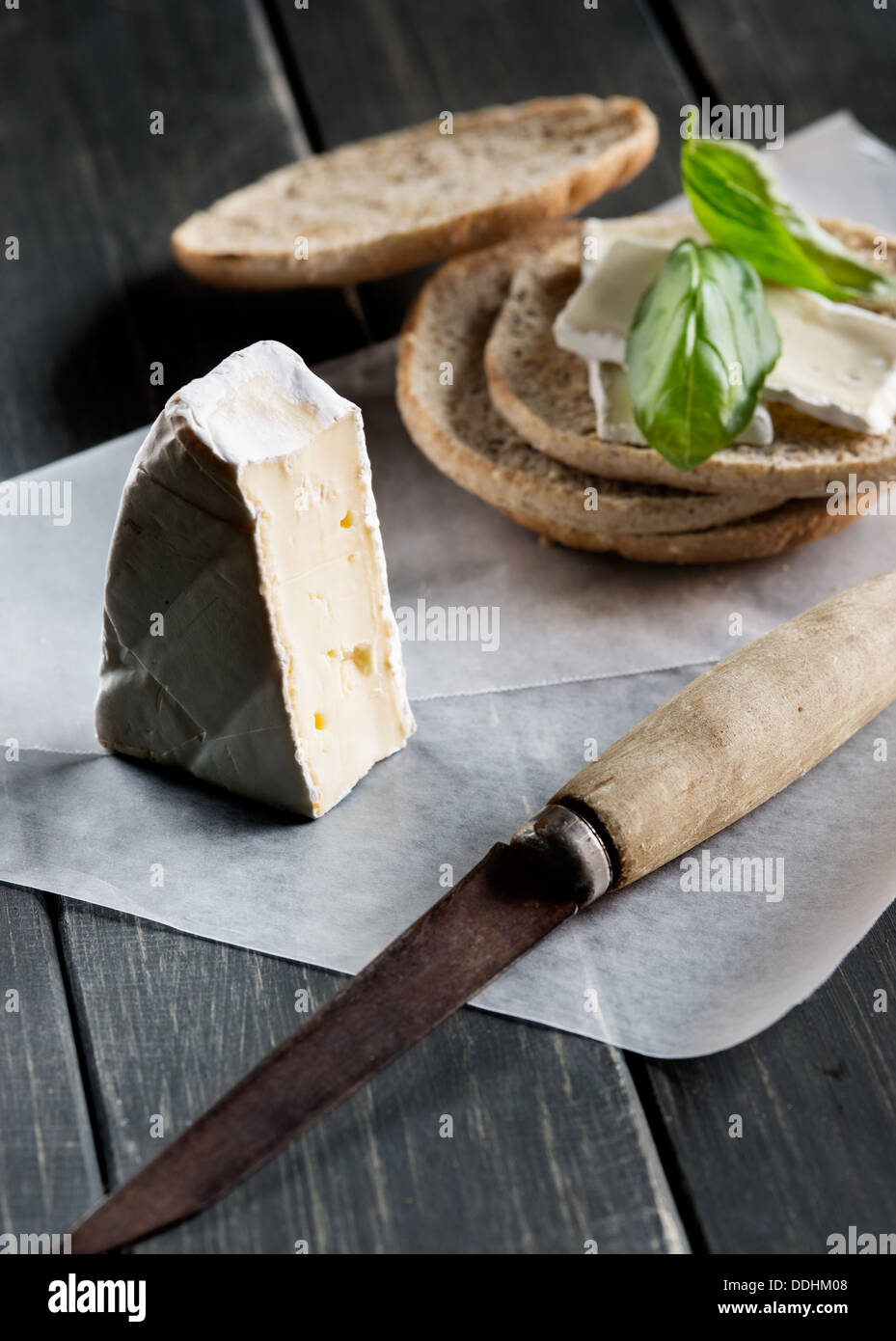 Brie cheese and toasts on black rustic wooden background Stock Photo