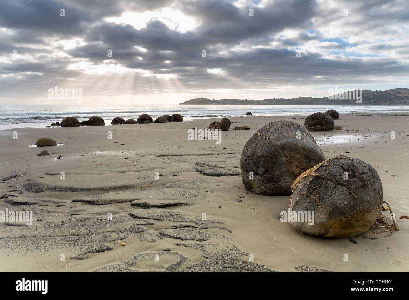 Moeraki Boulders on the beach with sunbeams in the early morning Stock Photo