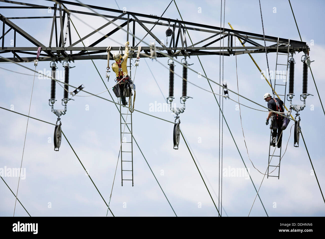 High-voltage service technicians installing a new high voltage power line Stock Photo