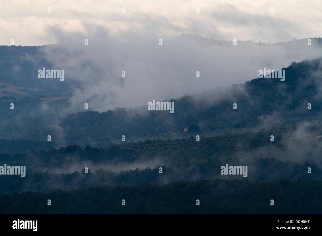early morning low lying cloud cover rising up through the hills around Piegaro near Perugia in Umbria Stock Photo