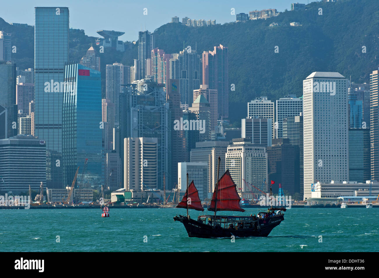 Traditional Chinese junk sailing before the skyscrapers of Hong Kong Central District Stock Photo